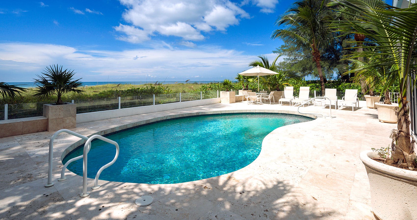 An open-air elevated porch, overlooking both the gulf and a swimming pool